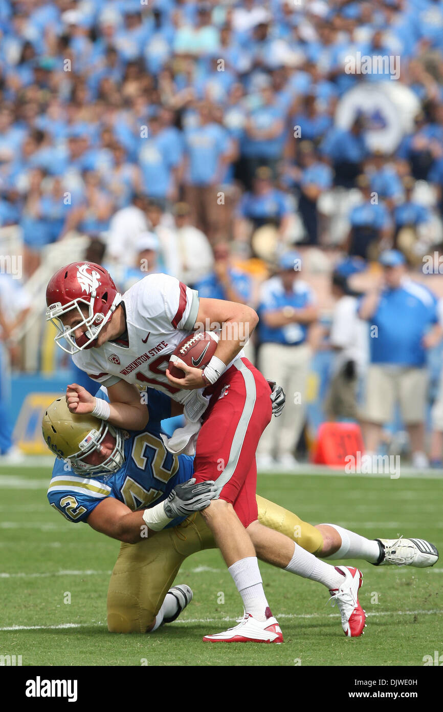 Le 2 octobre 2010 - Pasadena, California, United States of America - Washington State Cougars quarterback Jeff Tuel # 10 (avant) brouille et s'attaquer par le secondeur UCLA Bruins Patrick Larimore # 42 (retour) au cours de l'UCLA vs Washington State game au Rose Bowl. L'UCLA Bruins a ensuite battu les Cougars de l'État de Washington avec un score final de 42-28. (Crédit Image : © Brandon Parr Banque D'Images