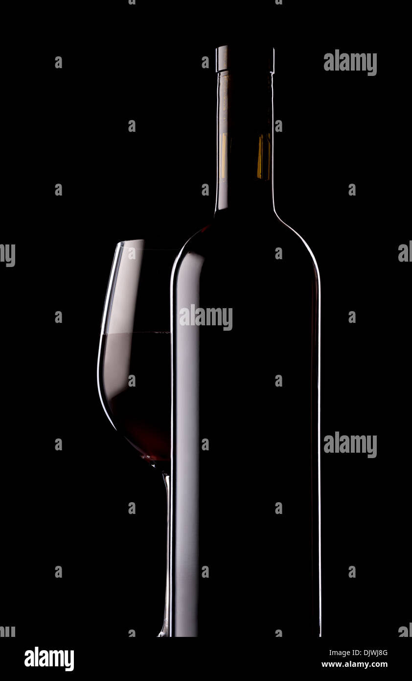 Verre et bouteille de vin rouge sur fond noir Banque D'Images