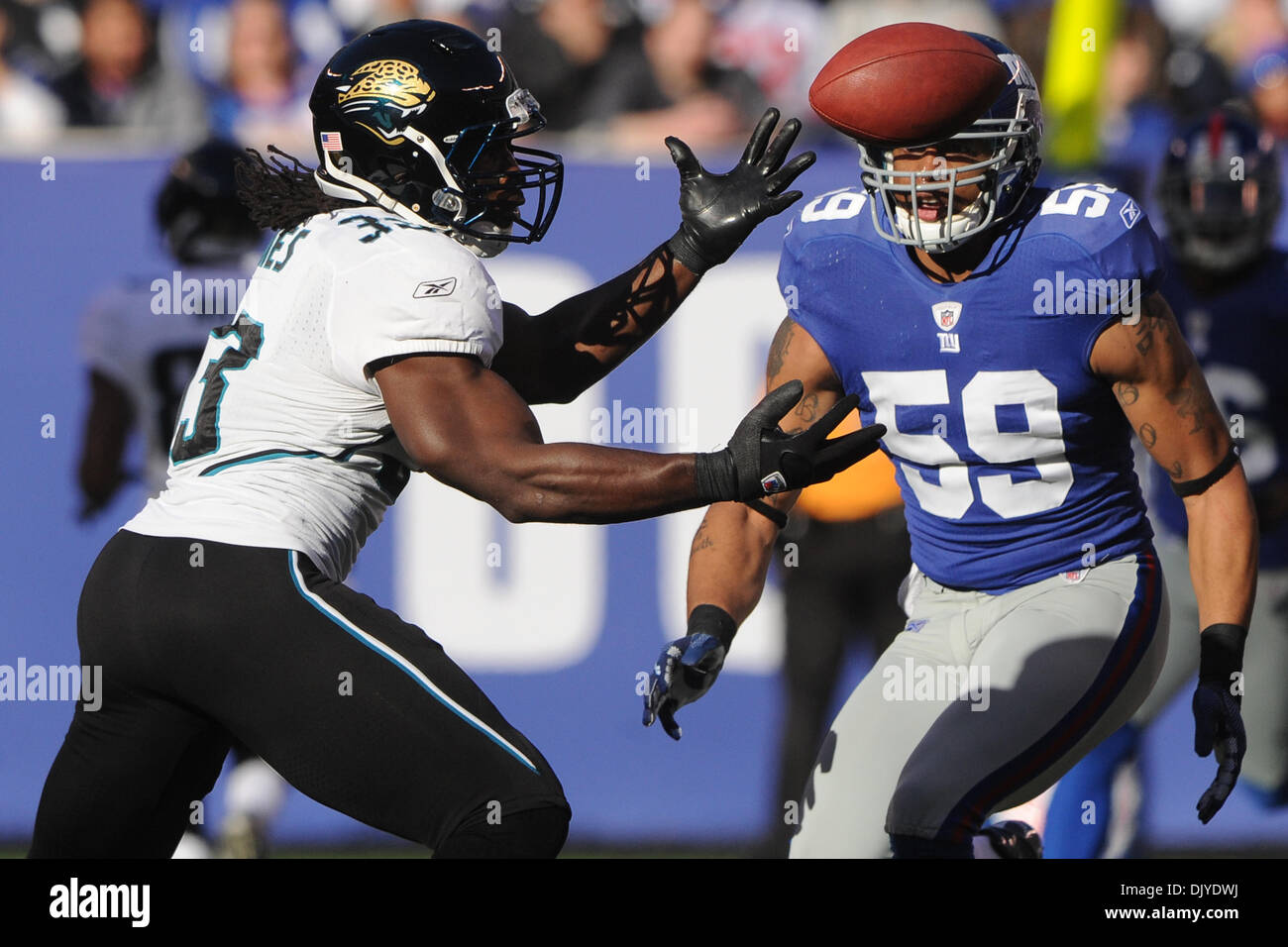 Jacksonville Jaguars fullback Greg Jones (33) attrape la balle avec les Giants de New York de secondeur Michael Boley (59) portant sur lui durant la première moitié de la semaine 12 l'action de la NFL entre les Giants de New York et Jacksonville Jaguars au New Meadowlands Stadium à East Rutherford, New Jersey. Les jaguars conduire les Giants 17-6 à la demie. (Crédit Image : © Vous Schneekloth Southcreek/global/ZUMAPRESS. Banque D'Images