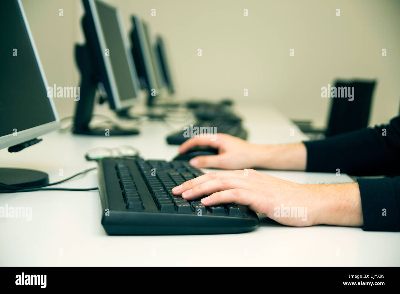 Jeune homme de taper au clavier. Salle de formation en informatique Banque D'Images