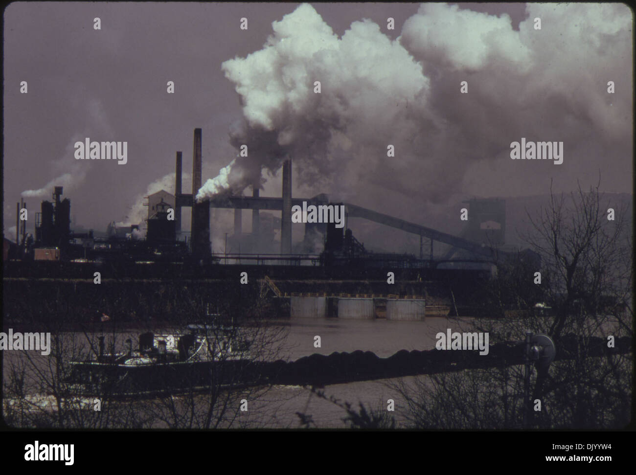Cette photo montre une barge à charbon se déplaçant sur la rivière Monongahela près d'une cokerie de la United States Steel Corporation à Clairton. La barge transporte du charbon, une matière première essentielle pour la production d'acier, soulignant le rôle du fleuve dans le transport industriel. Banque D'Images