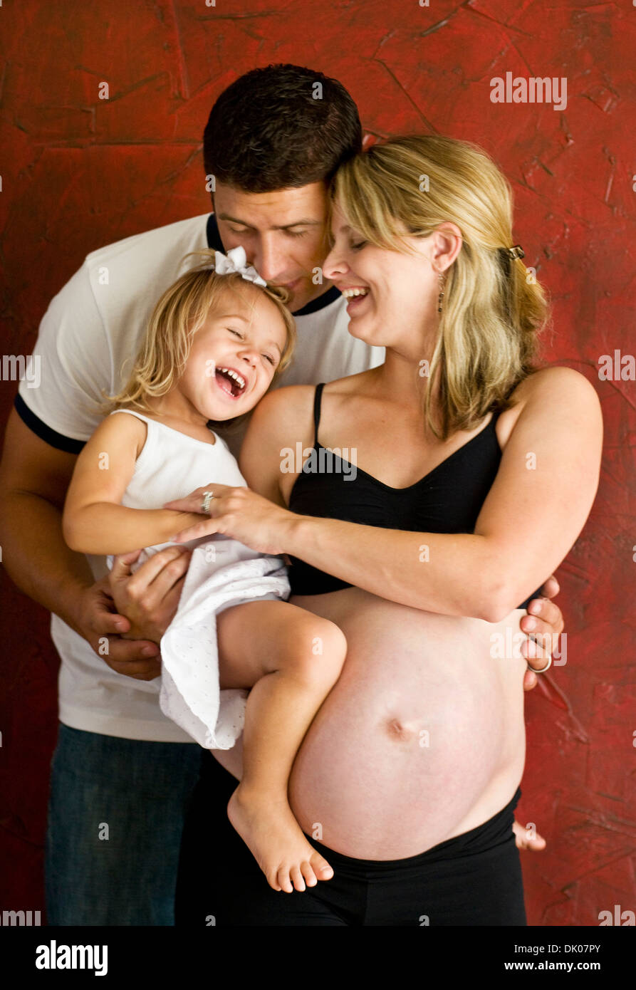 Un monsieur Caucasian woman et son mari M. Young jouer avec leur fille de deux ans au cours de leur séance photo de maternité. Banque D'Images