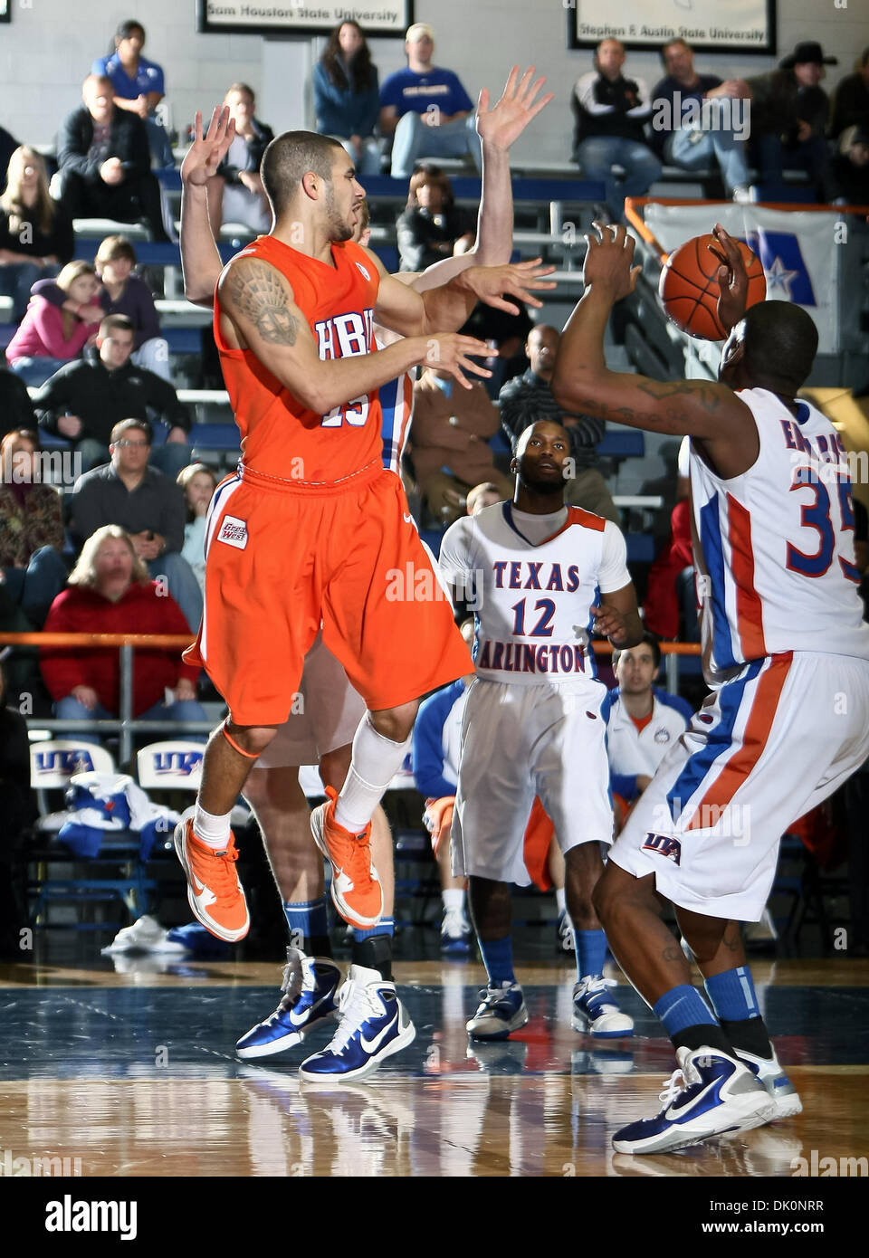 5 janvier 2011 - Arlington, Texas, United States of America - Houston Baptist garde Huskies Shawn Echols (15) fait un beau passage entre Texas-Arlington Mavericks guard Shaquille White-Miller (12) et Texas-Arlington Mavericks avant Brandon Edwards (35) dans le jeu entre l'UTA et le Houston Mavericks Huskies Baptiste a tenu à l'Université du Texas à Arlington's Texas Hall à Banque D'Images