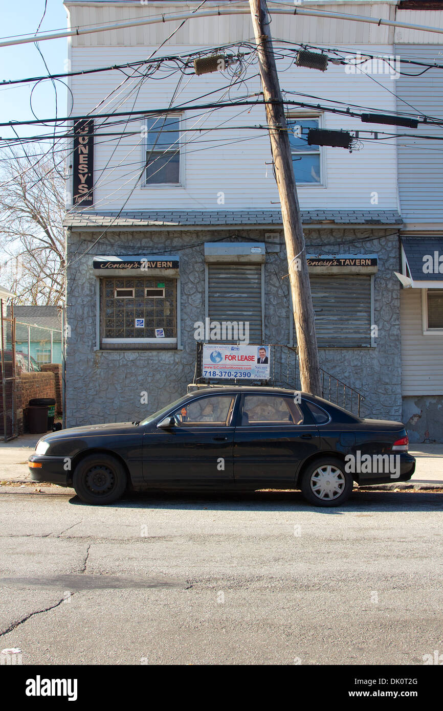 Vitrine vide désolées et vieille voiture à Staten Island, New York, NY USA. Banque D'Images