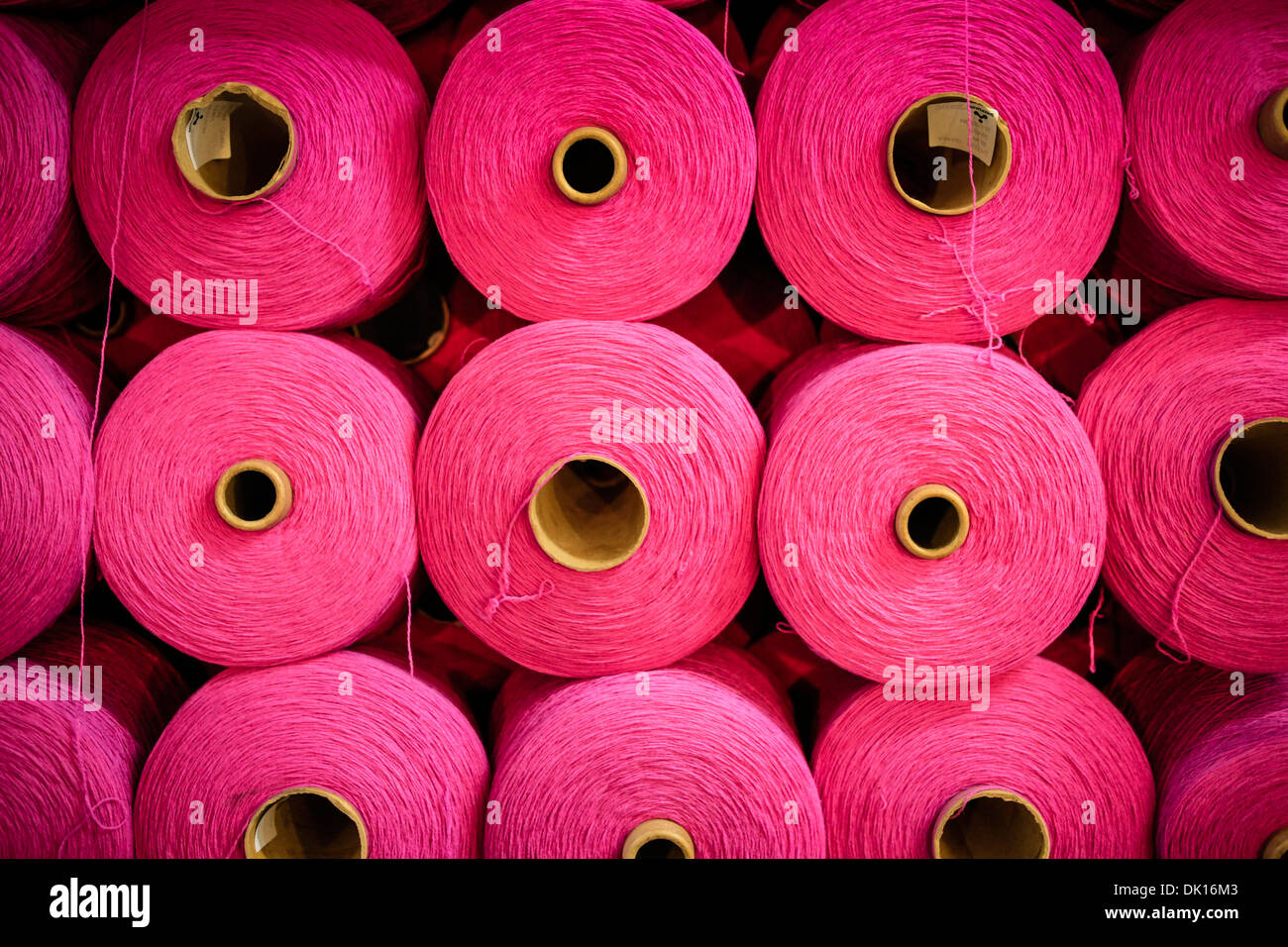 Bobines de ficelle en coton rose vif utilisé dans le tissage de textiles Banque D'Images