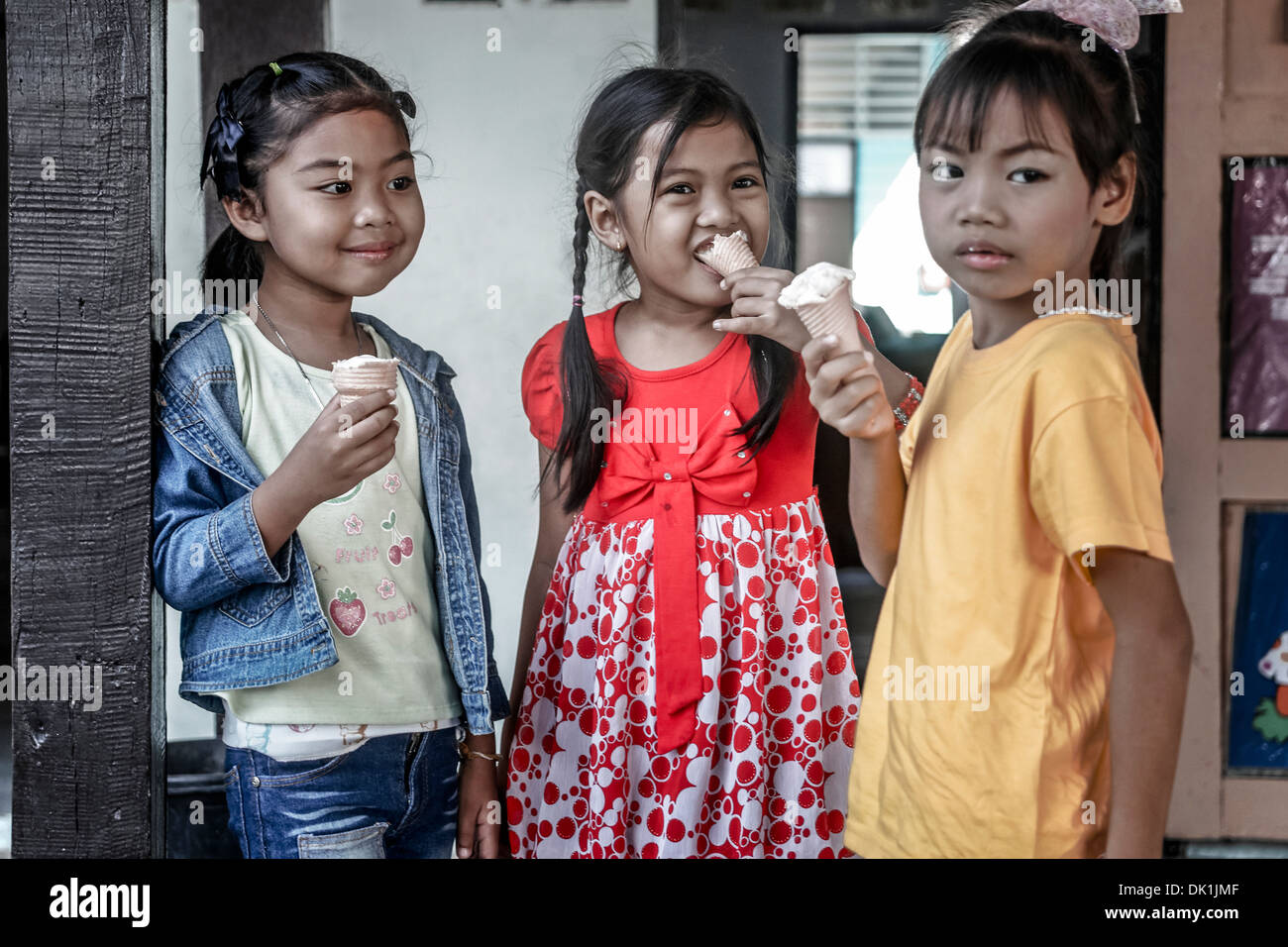 Les enfants mangent de la glace. Trois jeunes filles thaïlandaises qui mangent de la glace . Thaïlande S. E. Asie Banque D'Images