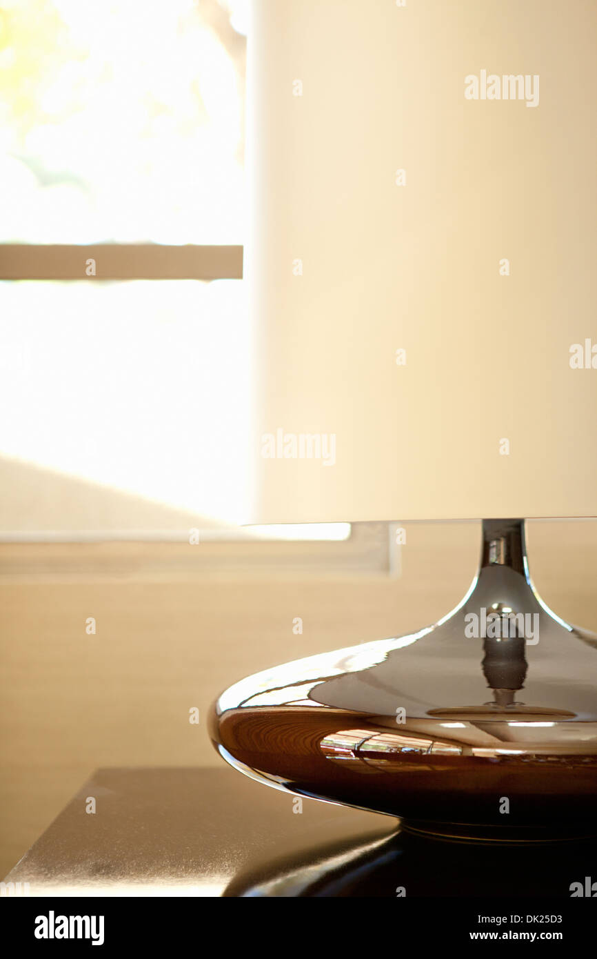 Close up of modern lampe avec abat-jour blanc sur la table par fenêtre Banque D'Images