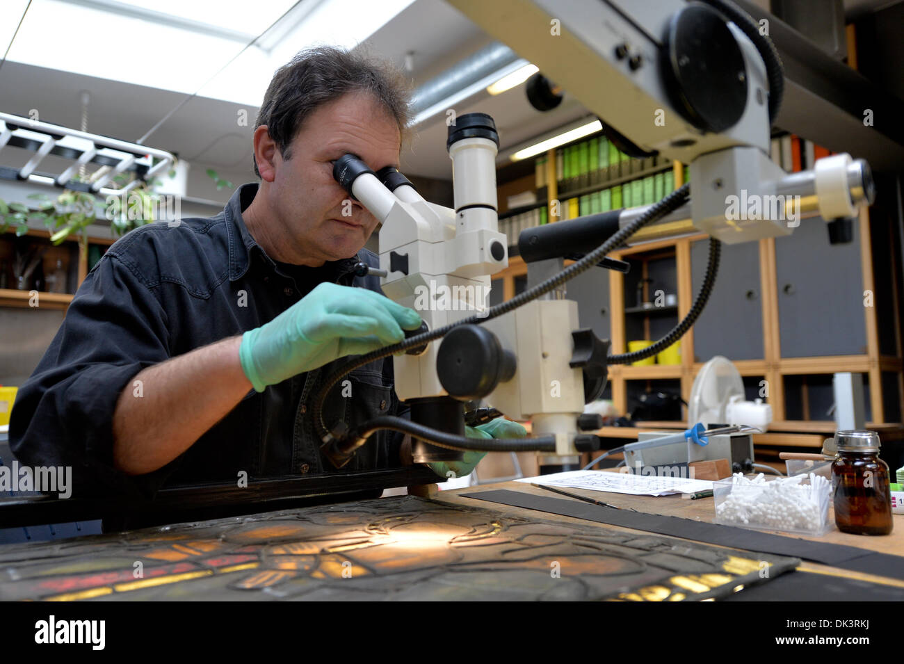 Erfurt, Allemagne. 27 nov., 2013. Thomas le verre, Glazier et restaurateur dans l'atelier de verre de la cathédrale d'Erfurt, nettoie un construit de la fenêtre de la cathédrale de Erfurt, Allemagne, 27 novembre 2013. La restauration d'une fenêtre de la Cathédrale qui se compose d'environ 100 panneaux unique prend environ deux ans. Les fenêtres ont été faits dans les années entre 1380 et 1420. Photo : Marc Nrit/ZB/dpa/Alamy Live News Banque D'Images