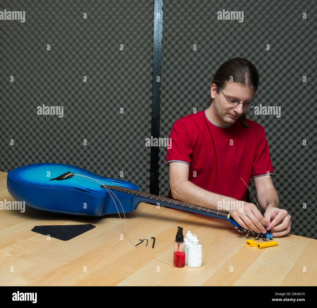 Technicien guitare de remplacer les cordes d'une guitare électro-acoustique ( série avec le même modèle disponible) Banque D'Images