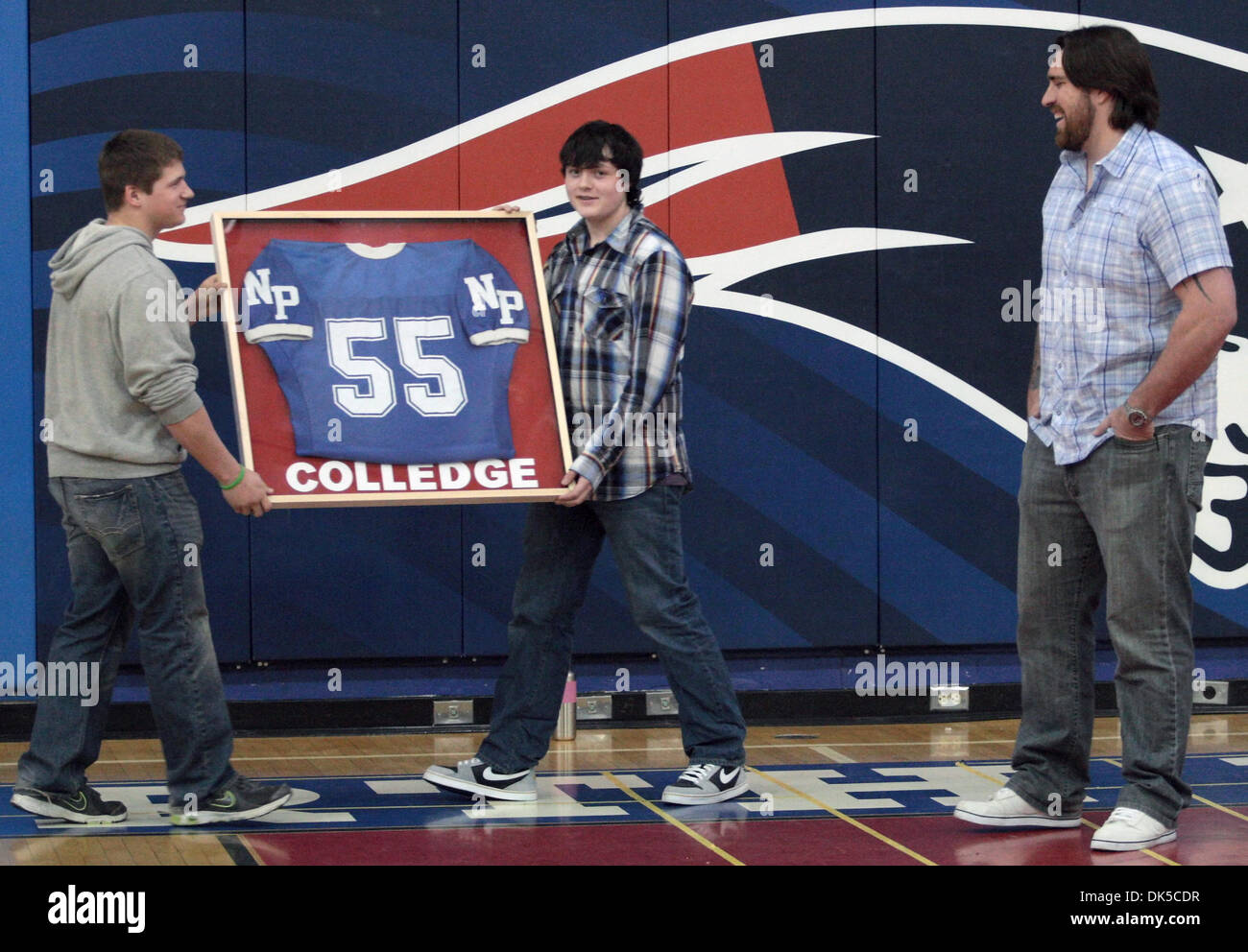 29 avril 2011 - Fairbanks, AK, États-Unis - Sam Harrel/News-Miner.Champion Superbowl et Daryn Colledge supérieures au pôle nord est présenté avec son chandail des Patriotes au cours d'une assemblée générale vendredi après-midi, le 29 avril 2011, à l'école. Ryan Wentland, gauche, et Garrett Bennett, moyen, faire la présentation. Colledge est un poseur de avec les Packers de Green Bay qui a remporté cette année, le Superbowl. Il gr Banque D'Images