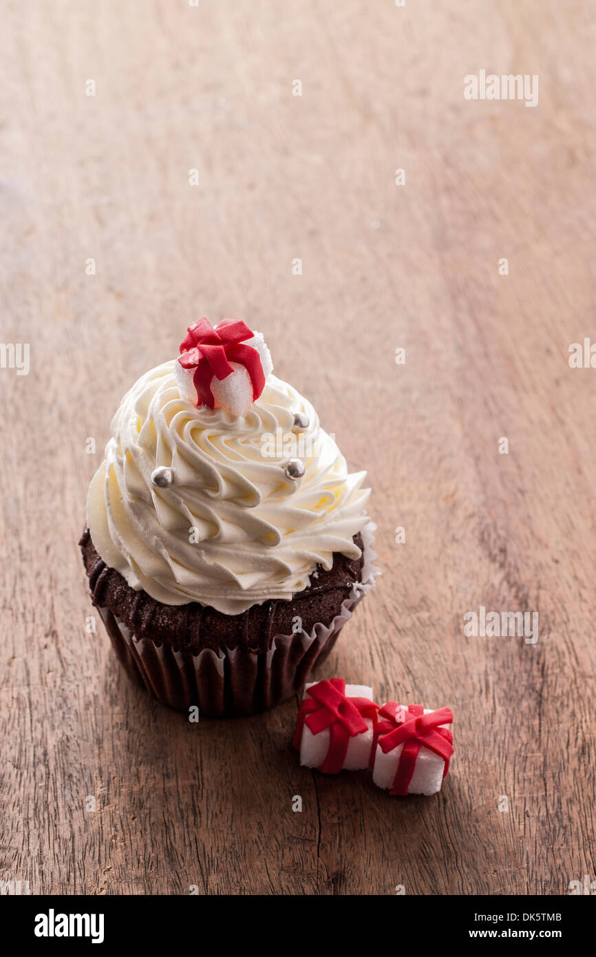 Cupcake de Noël décoré avec boîte-cadeau sur table en bois Banque D'Images