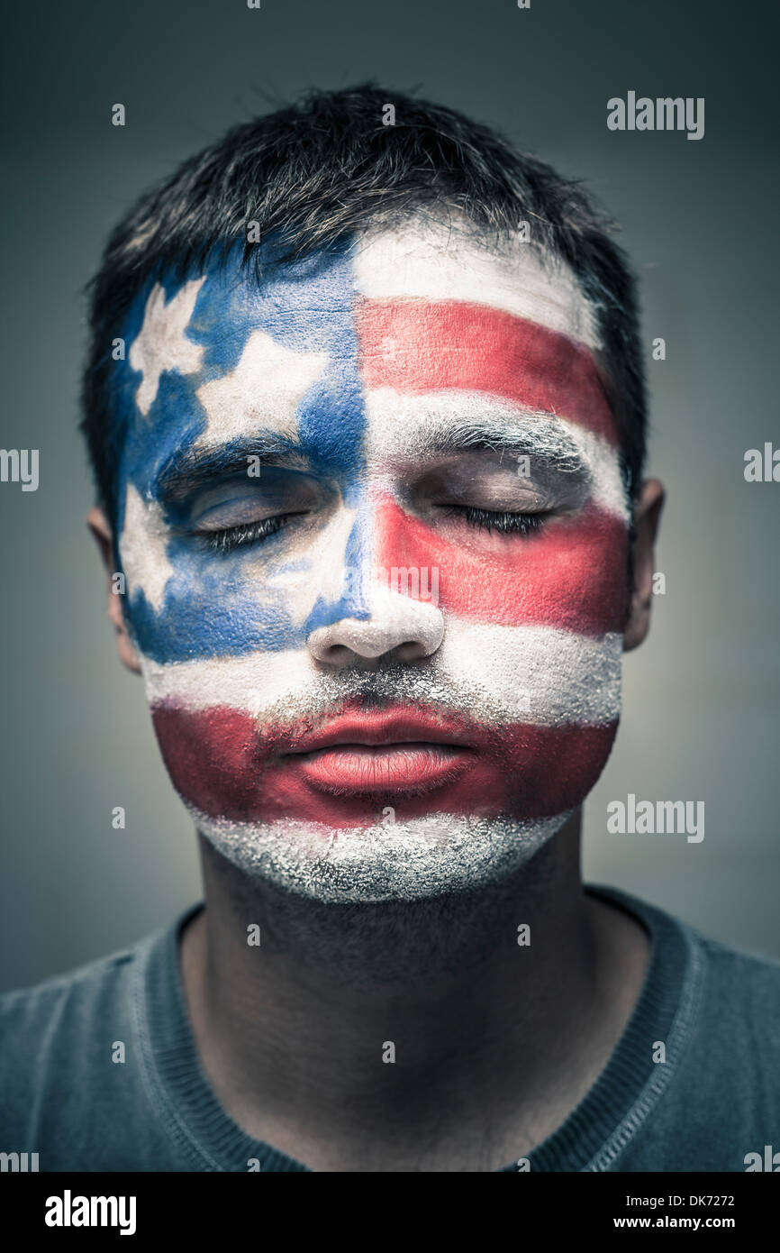 Portrait d'homme avec USA flag peint sur son visage et ferma les yeux. Banque D'Images