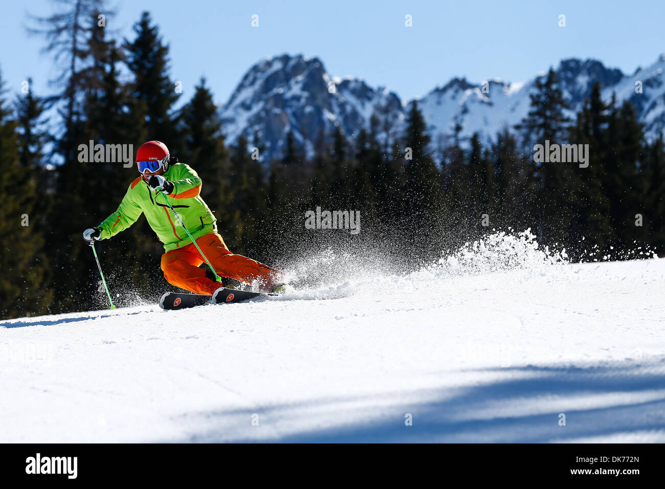 Close up d'un skieur faisant un tour parfait sur de très bonnes pistes de ski sur une journée ensoleillée et la pulvérisation de neige Banque D'Images