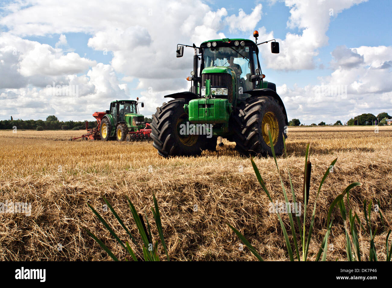 Tracteur John Deere champ Fenland hersage Banque D'Images