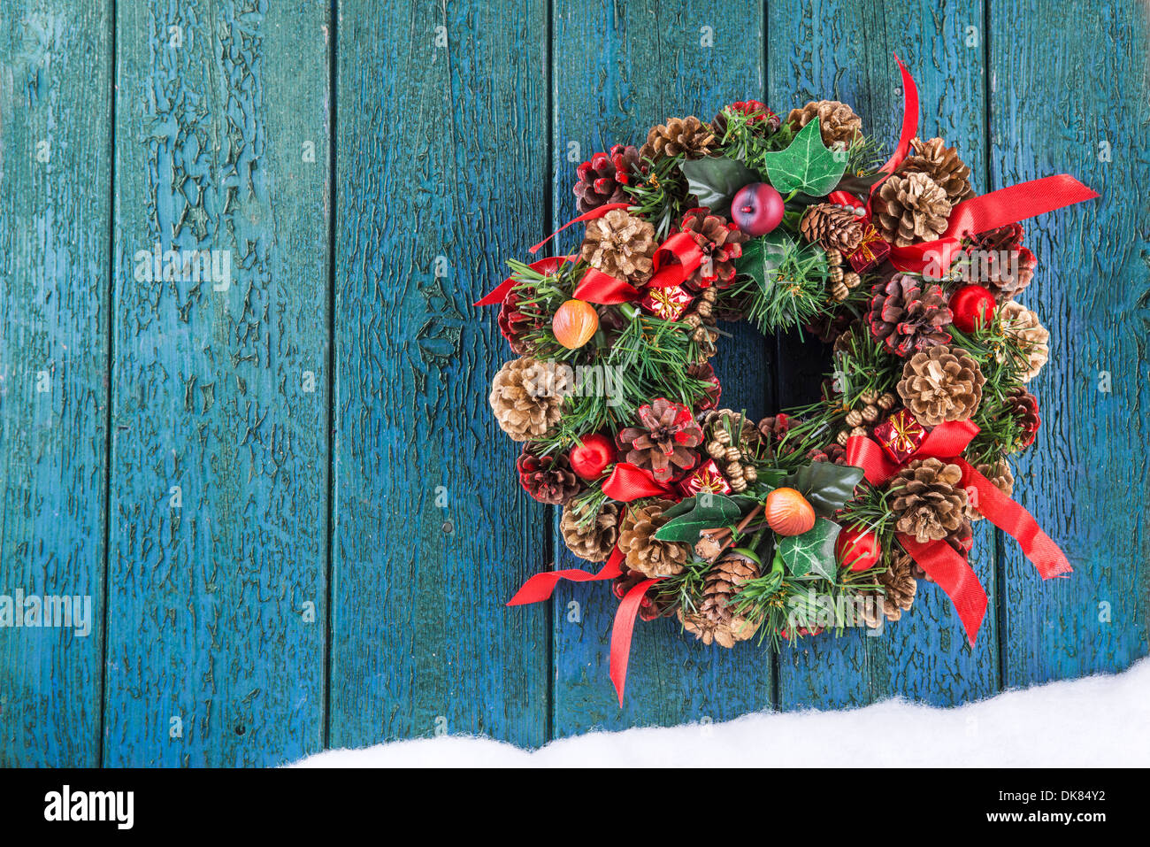 Une couronne de Noël accroché sur une vieille porte verte avec un espace réservé au texte Banque D'Images