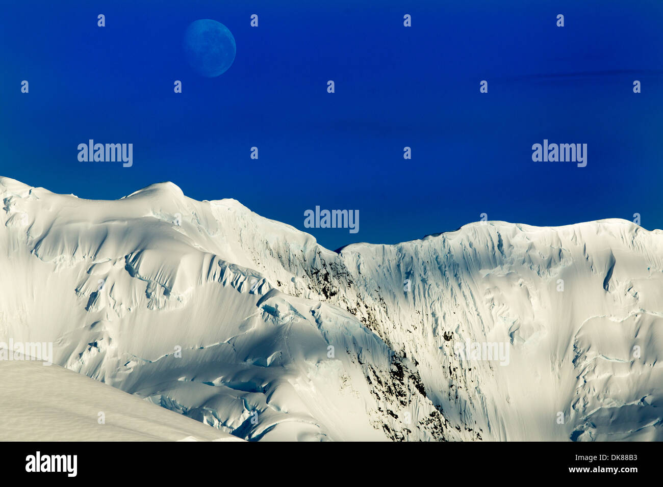 L'antarctique, Port Lockroy, lune se couche au-dessus du sommet du glacier, couverts de sommet de montagne le long de la péninsule Antarctique Banque D'Images