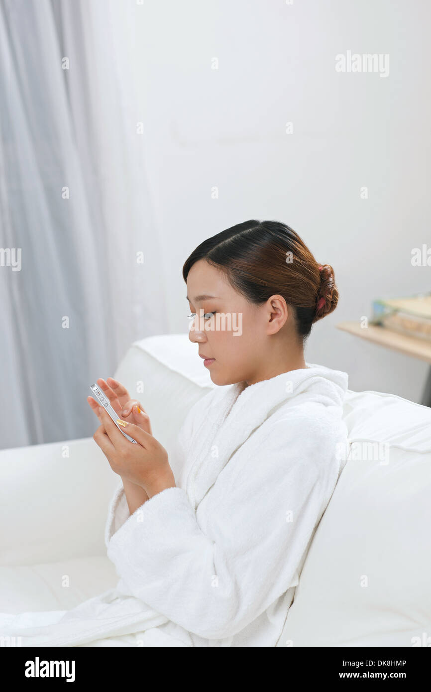 Young woman using smartphone in spa Banque D'Images