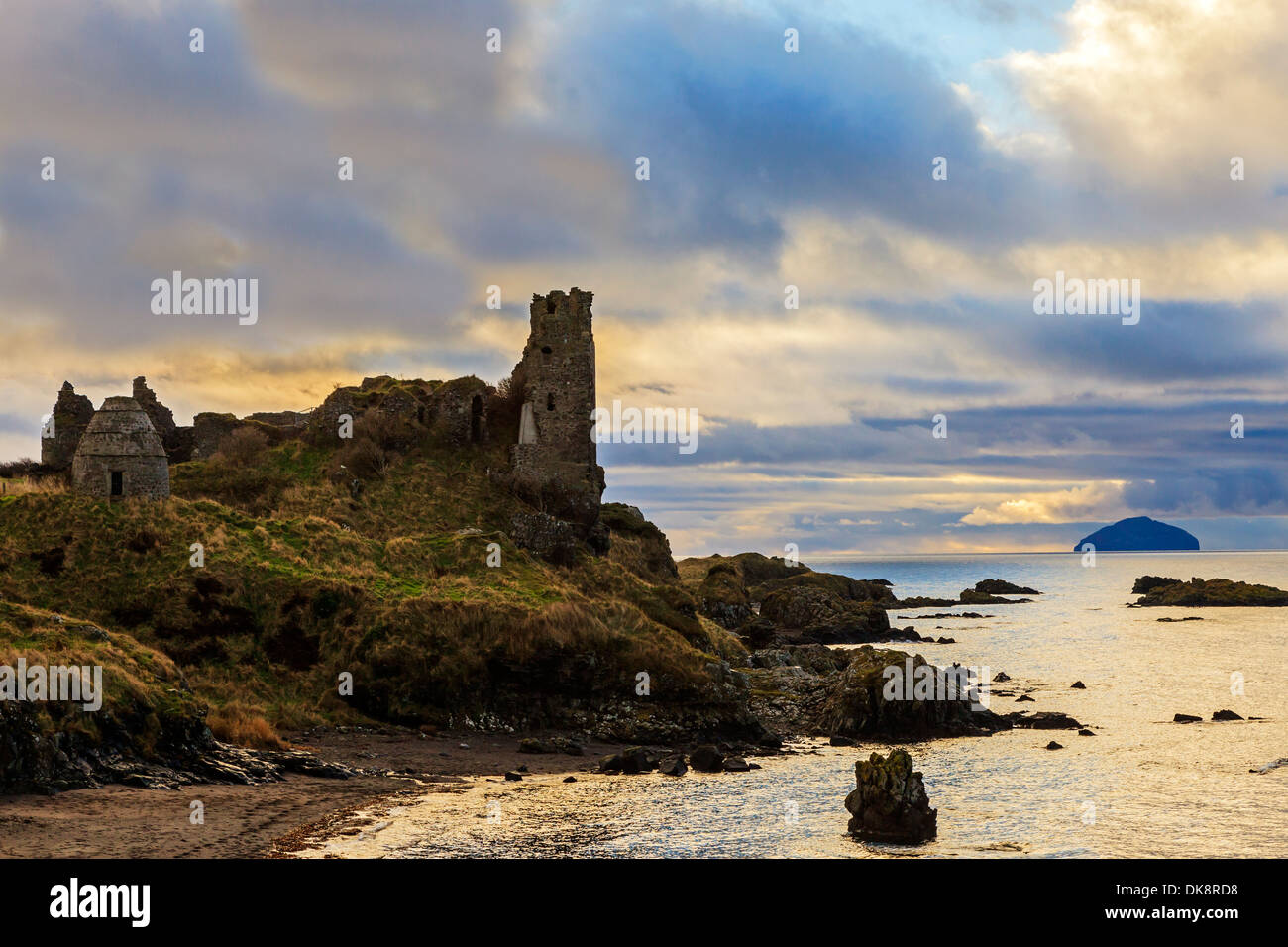 Château de Dunure au coucher du soleil surplombant le Firth of Clyde de l'île d'Ailsa Craig, dans la distance, Banque D'Images