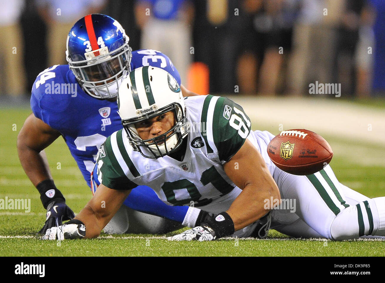 Le 29 août 2011 - East Rutherford, New Jersey, États-Unis - New York Jets tight end DUSTIN KELLER (81) tousse le ballon après avoir fait un crochet dans le deuxième trimestre d'une présaison NFL match contre les Giants de New York au Stade MetLife. Keller a été jugée irrecevable par le bas donc pas de contact sur le fumble jouer. À gauche est New York Giants running back DA'REL SCOTT (34). (Crédit Image : © Brooks Von A Banque D'Images
