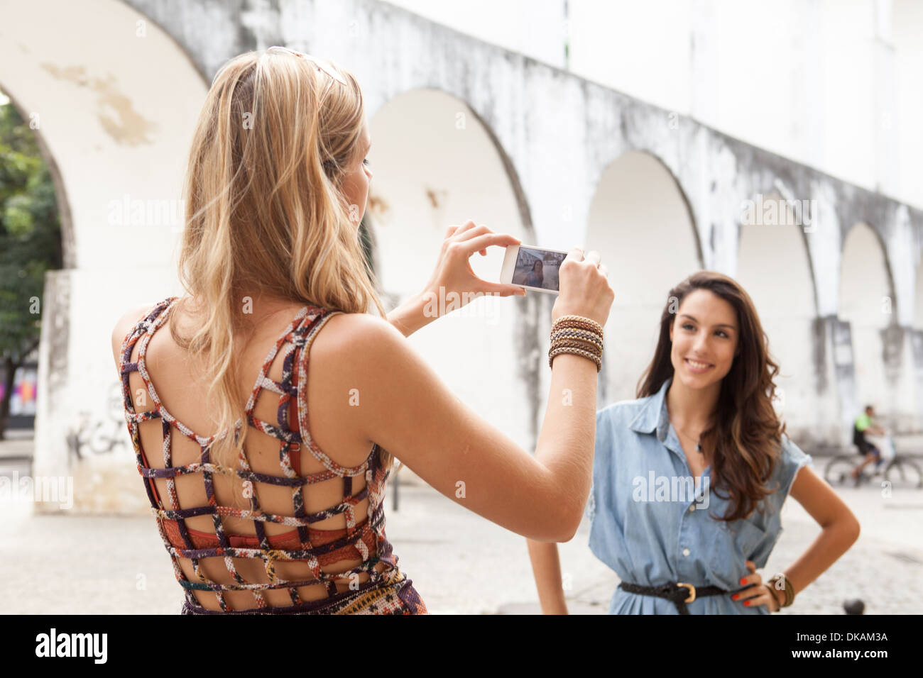 Young woman taking photo d'ami en face de l'Aqueduc de Carioca, Rio de Janeiro, Brésil Banque D'Images