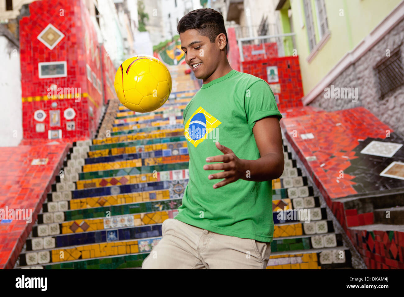 Jeune homme portant Brésil page faire uppys keepy en face de l'Escalier Selarón Escadaria de Rio de Janeiro, Brésil Banque D'Images