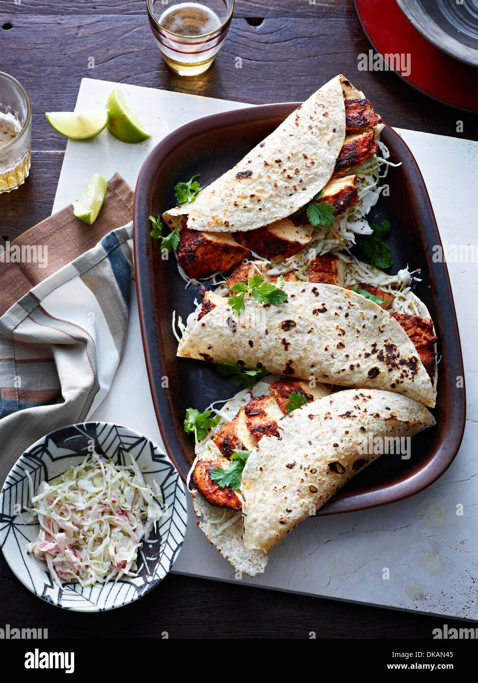 Table avec plat de tacos au poulet et fines herbes Banque D'Images