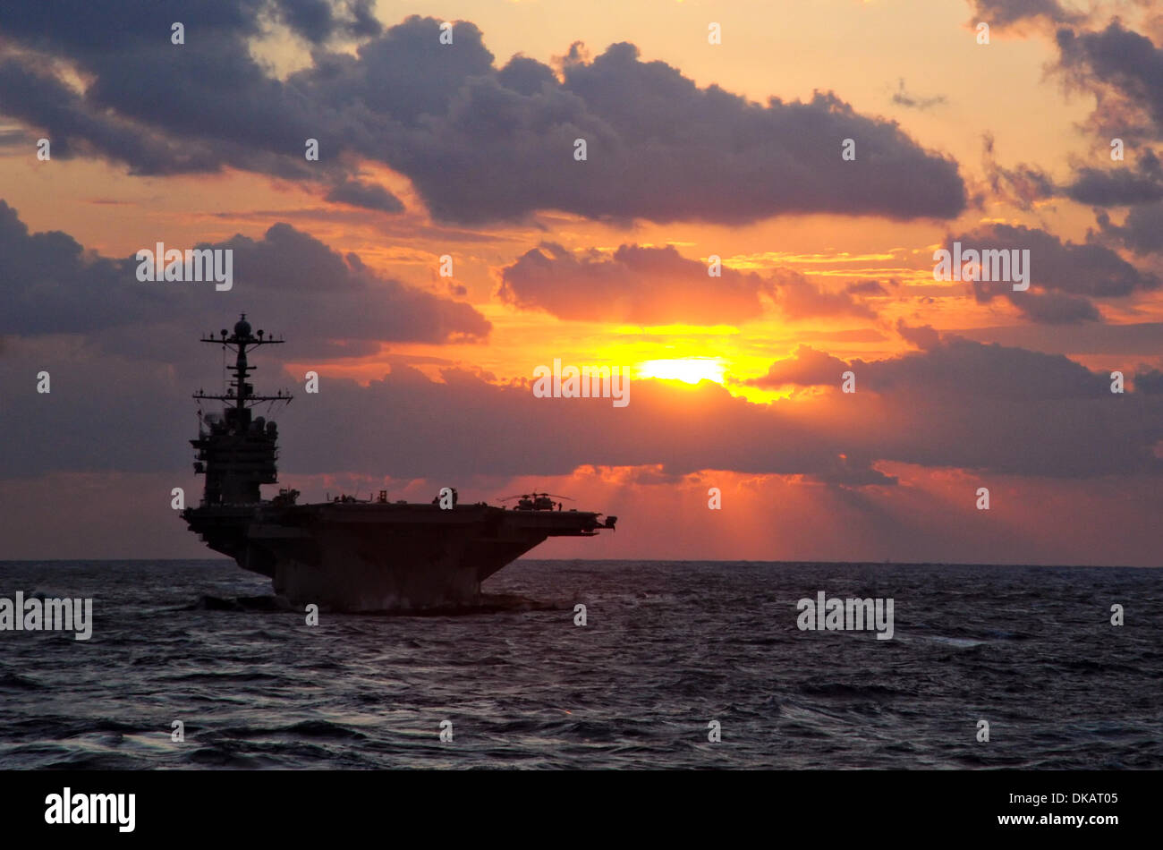 US Navy porte-avions nucléaire USS George Washington au cours de patrouilles coucher du soleil le 2 décembre 2013 dans l'ouest de l'océan Pacifique. Banque D'Images