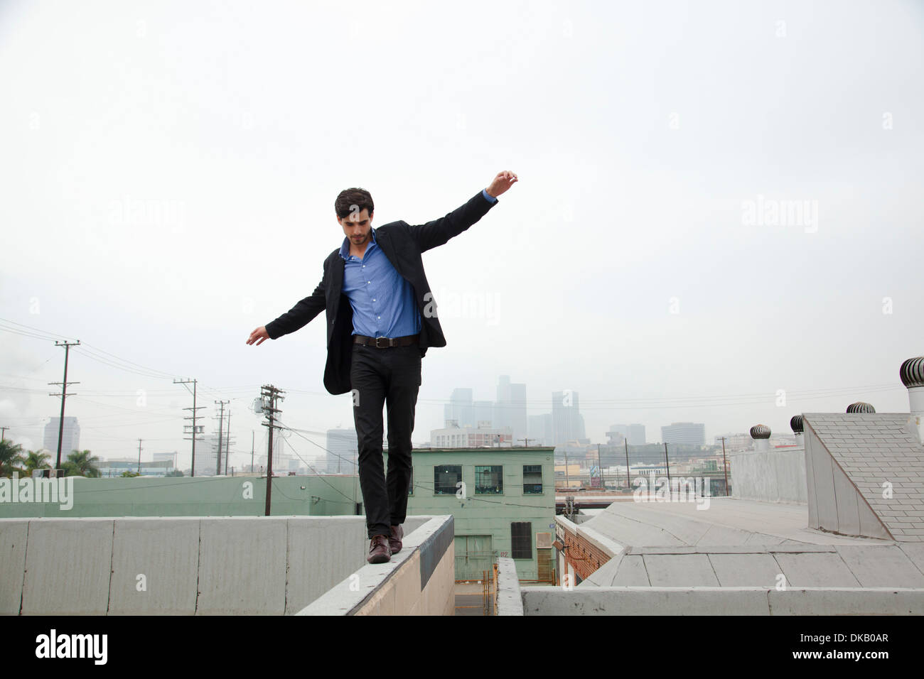 Jeune homme mur marche sur les toits de la ville Banque D'Images