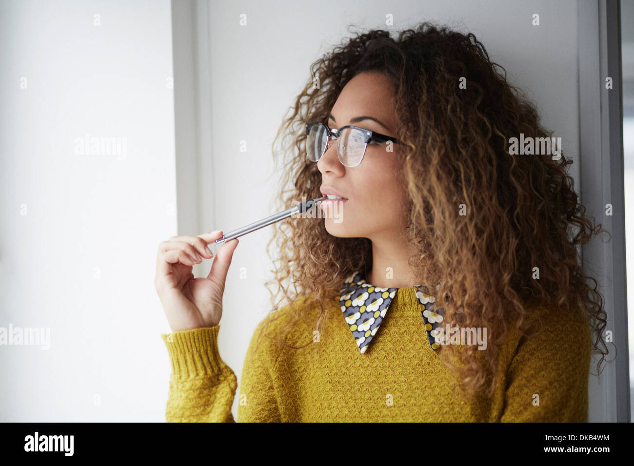 Female office worker holding pen Banque D'Images