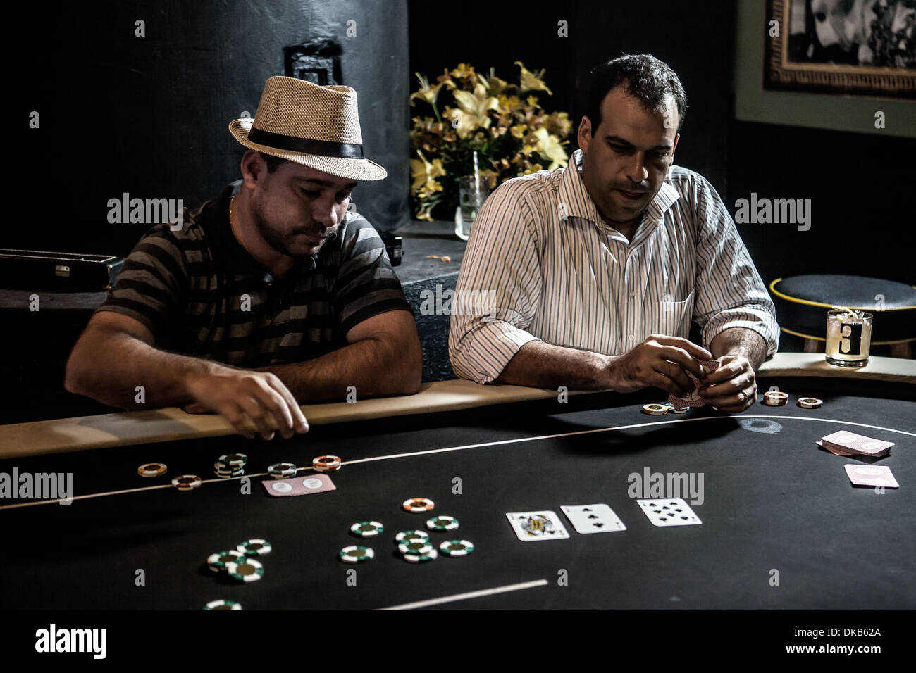 Mi les hommes adultes jouer au poker et boire des cocktails Banque D'Images