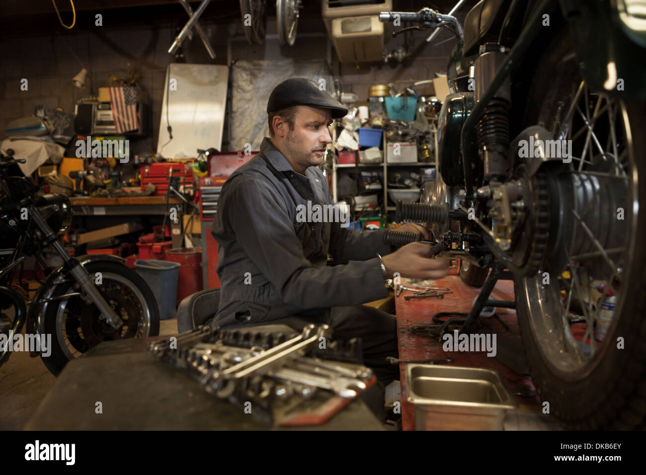 Mécanicien dans son garage à motos fonctionnant au gaz conversion Bio-Diesel Banque D'Images