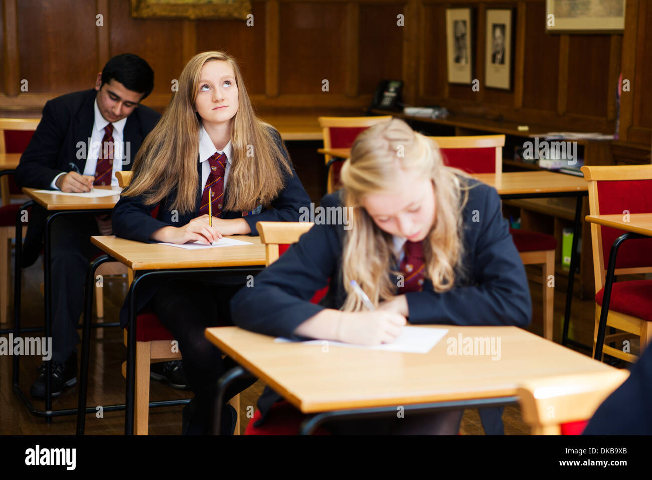 Groupe d'écoliers adolescents examen assis Banque D'Images