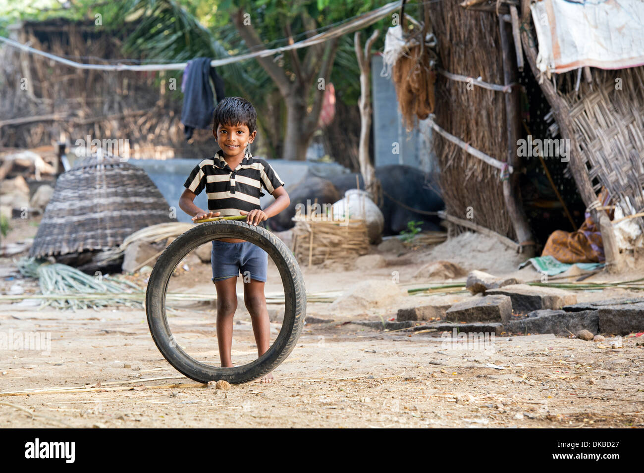 Village de l'Inde rurale Garçon jouant avec un pneu. L'Andhra Pradesh, Inde Banque D'Images
