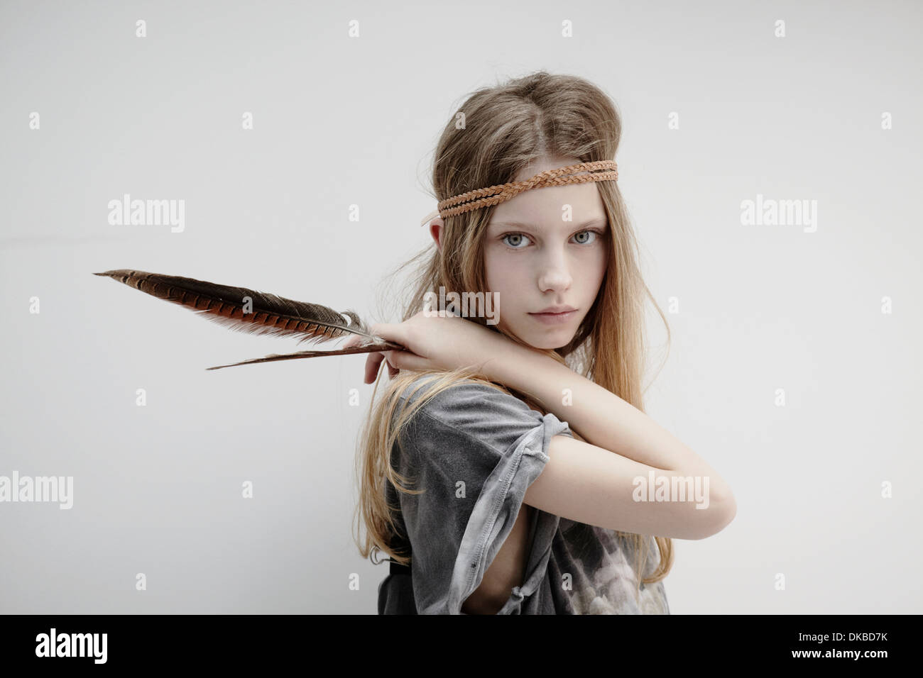 Portrait of Girl wearing tresse cuir autour de tête, holding feather Banque D'Images