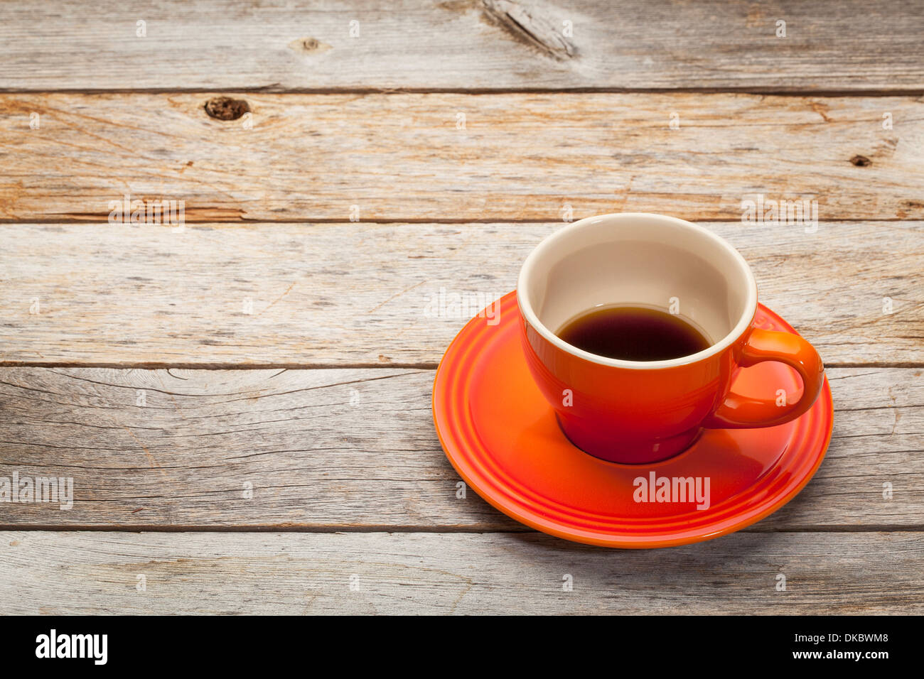 Tasse à café en grès orange sur une table en bois rustique Banque D'Images