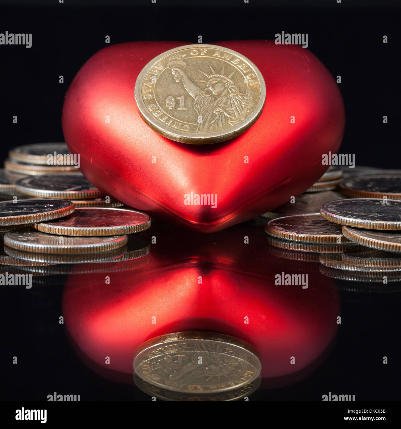 Coeur rouge et en dollars américains de pièces sur un tableau noir Banque D'Images