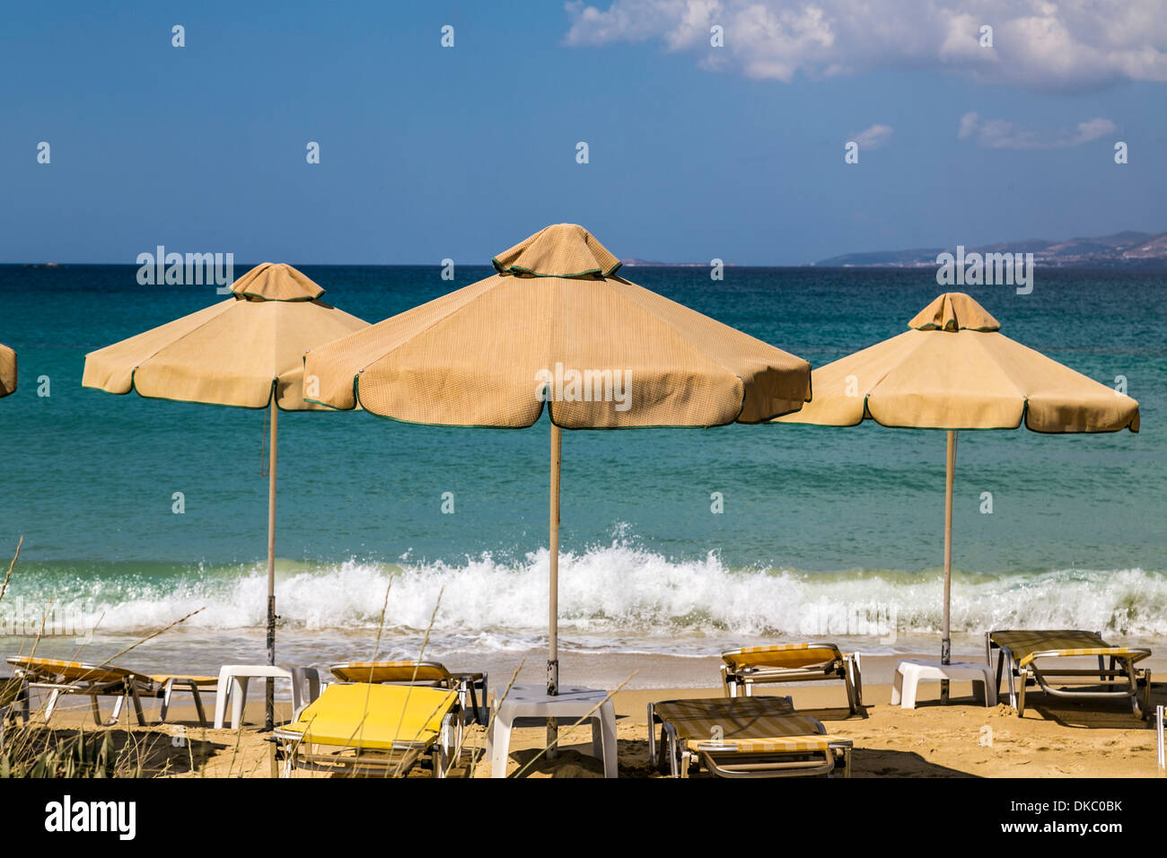 Trois orange, le vieux parasols et transat avec l'océan bleu en arrière-plan. Banque D'Images
