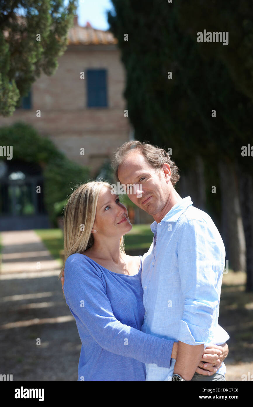 Mature couple standing in garden hugging Banque D'Images