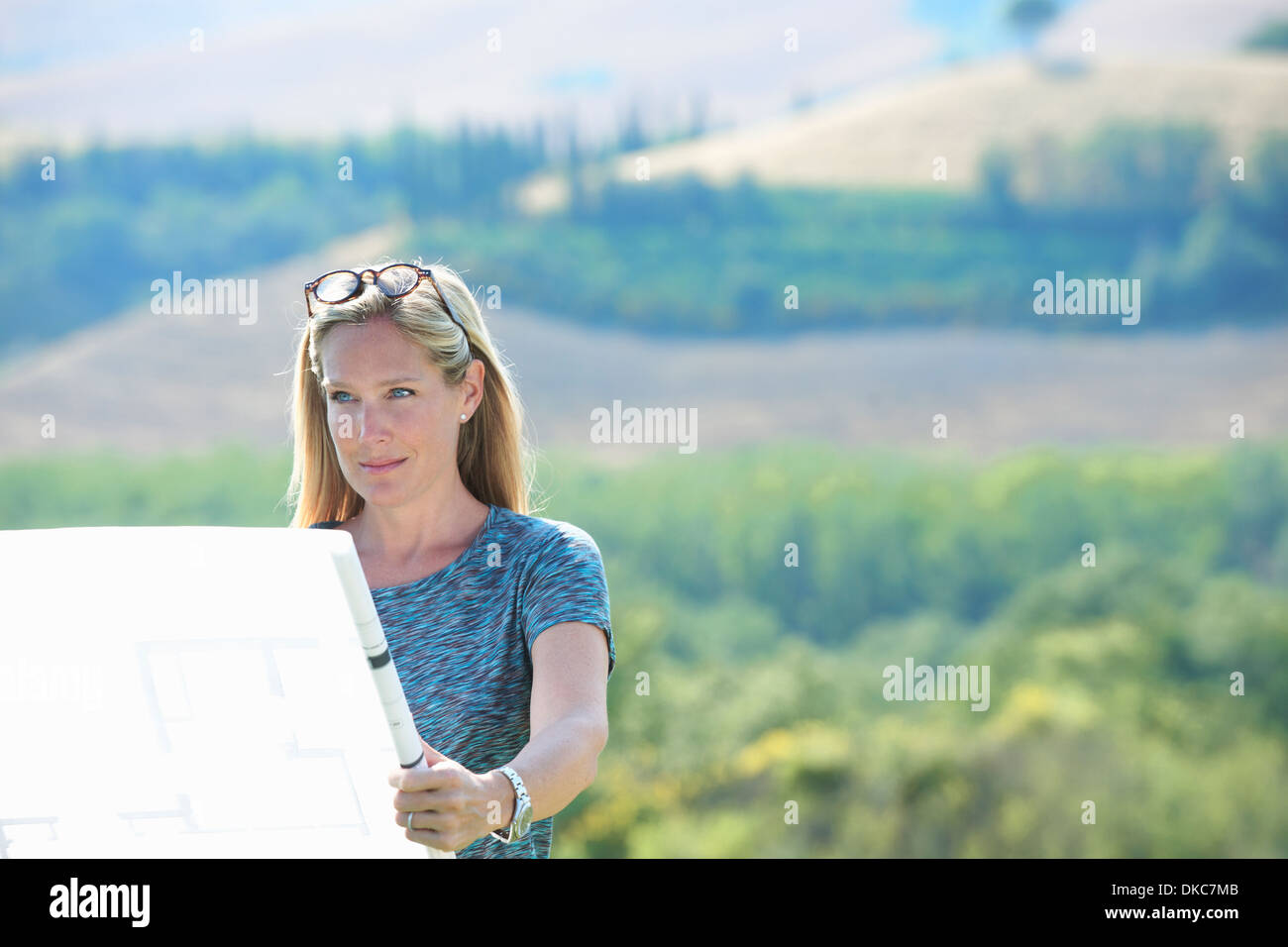 Young woman standing on mountain à la recherche de plans d'architectes Banque D'Images