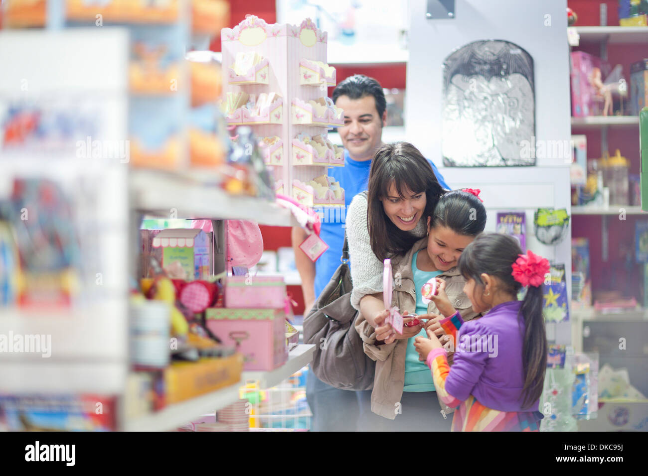 Famille avec deux filles shopping in toy shop Banque D'Images