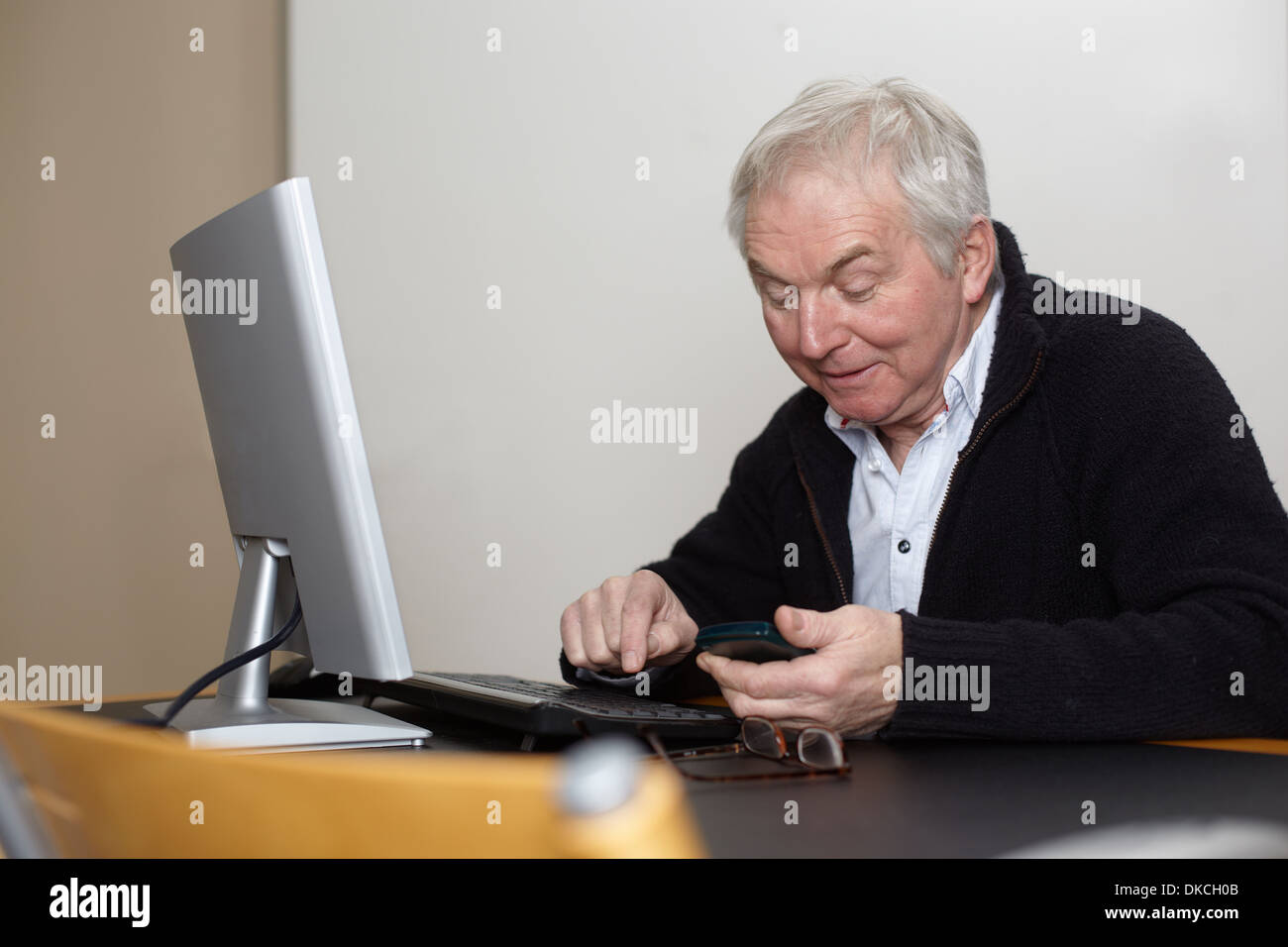 Senior à la maison à l'aide d'un ordinateur personnel Banque D'Images