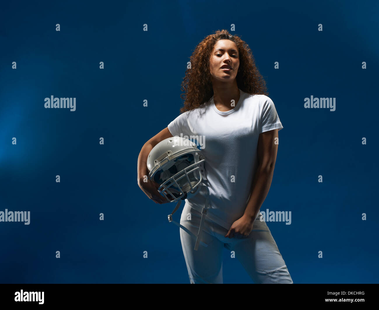 Portrait de femme footballeur américain holding helmet Banque D'Images
