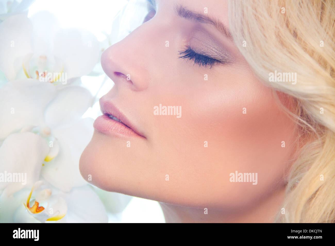 Close up of woman smelling orchidées Banque D'Images