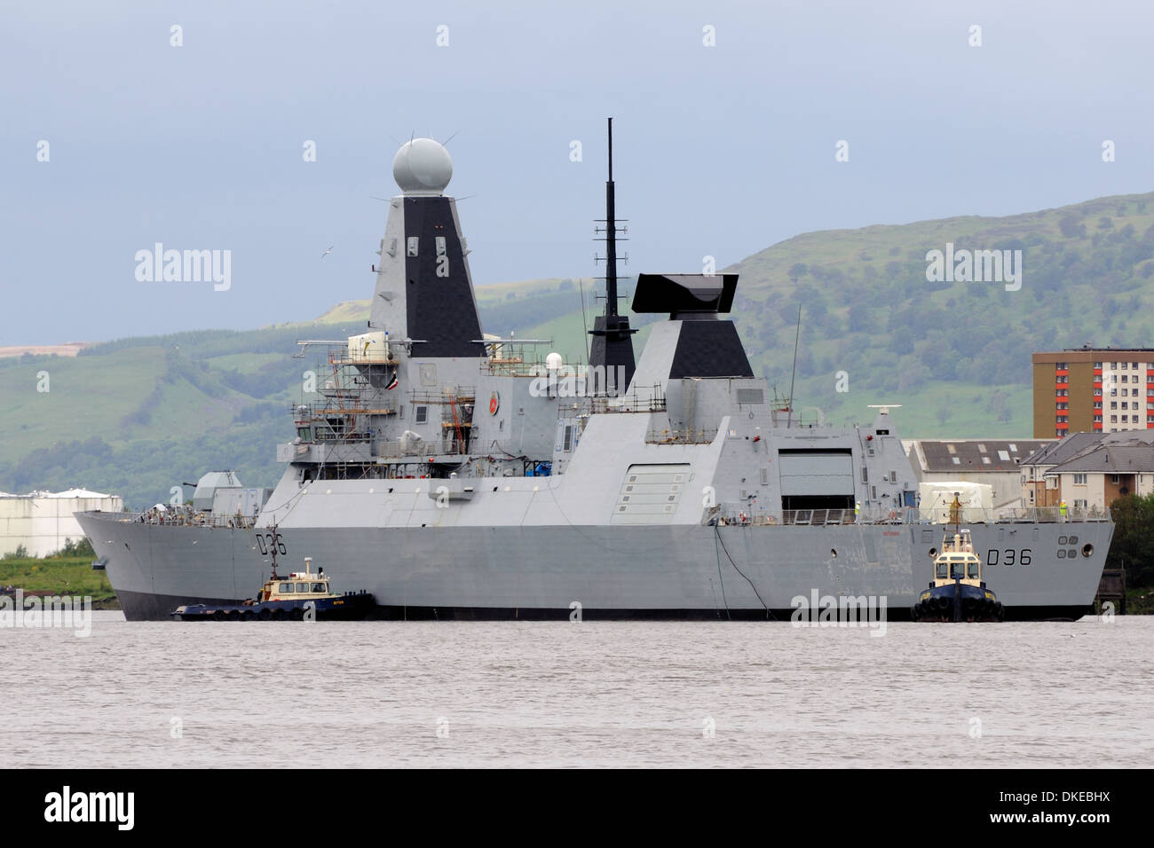 Le HMS Defender être manoeuvrés par des remorqueurs sur la rivière Clyde Banque D'Images