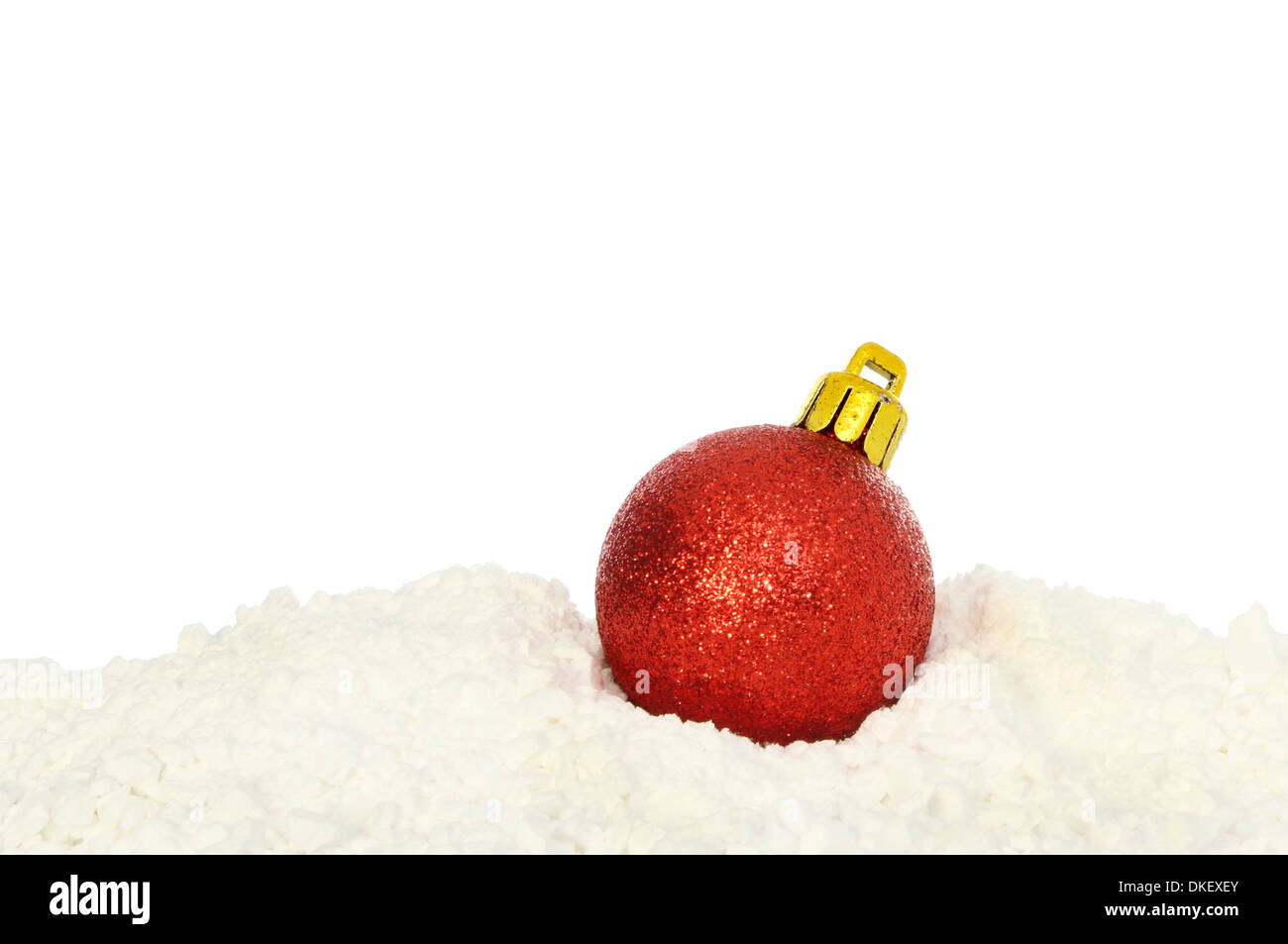 Boule de Noël rouge unique sur la neige sur un fond blanc. Banque D'Images