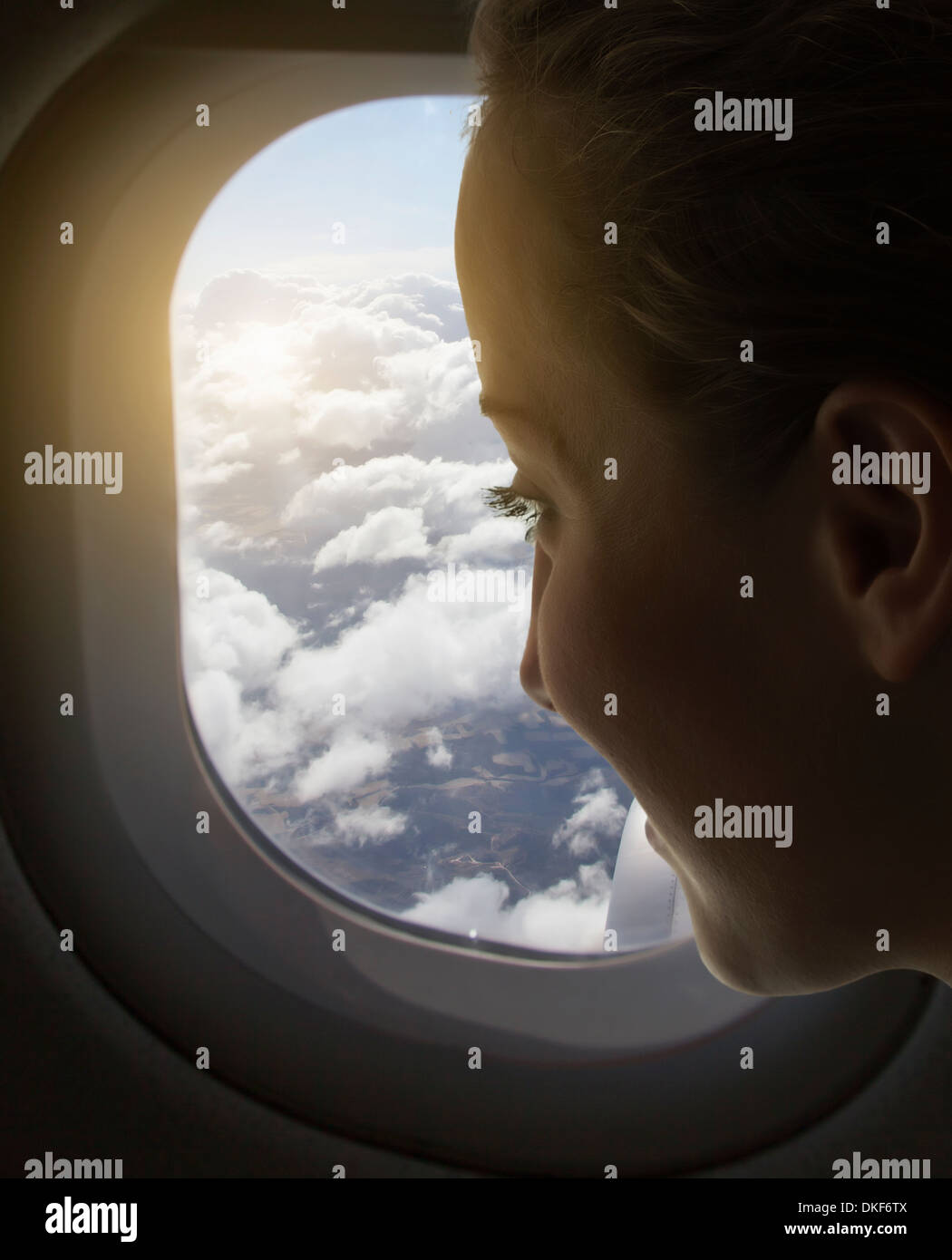 Femme regardant par la fenêtre de l'avion Banque D'Images