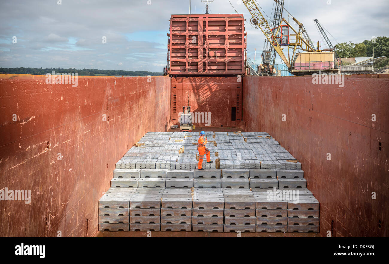 Worker lingots de métal dans la cale du navire Banque D'Images