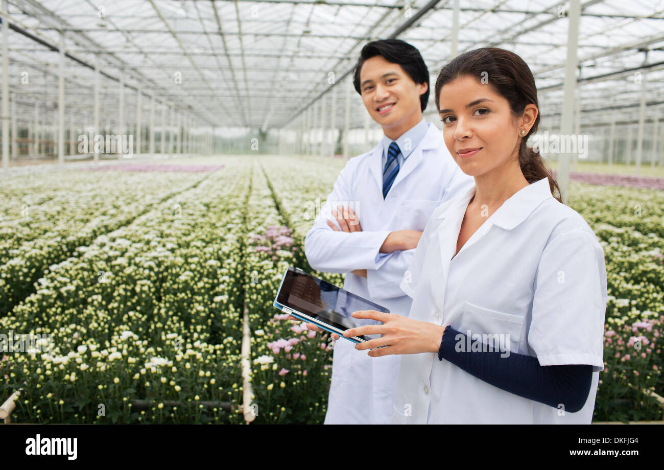 L'homme et de la femme avec des rangées de plantes poussant dans les émissions de Banque D'Images