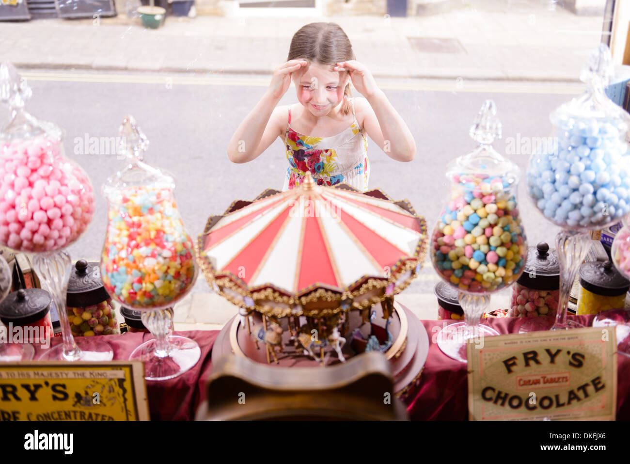 Fille à la fenêtre à travers de sweet shop Banque D'Images