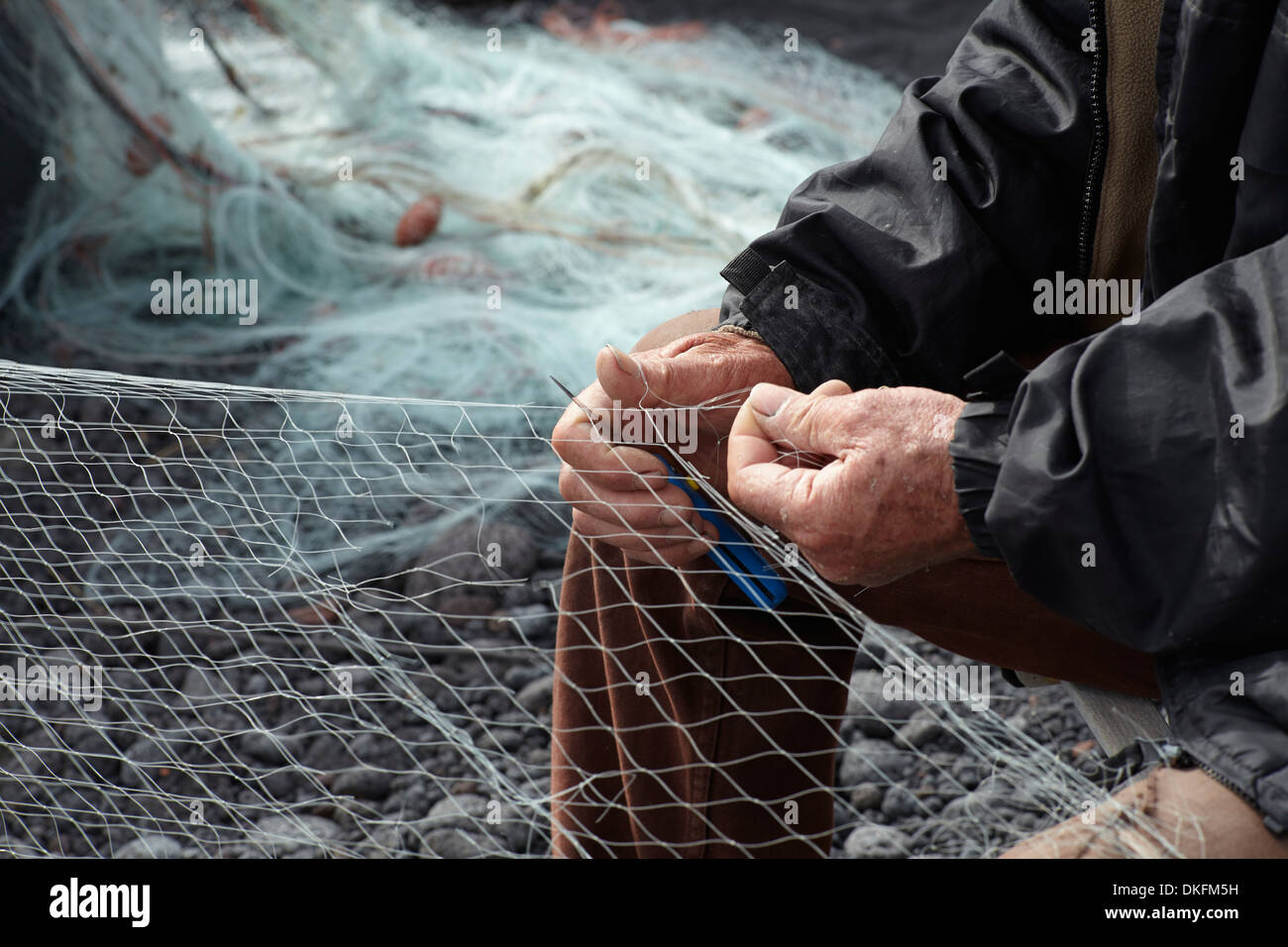 La réparation de pêcheur sur la plage de galets de net Banque D'Images